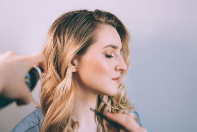 Close-up portrait of young woman against white background