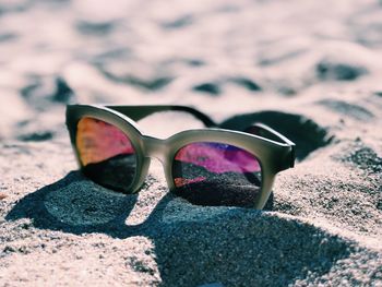 Close-up of sunglasses on beach