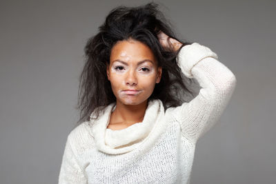 Portrait of young woman against wall