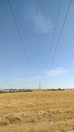 Electricity pylon on field against sky