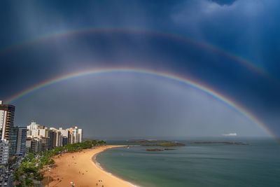 Scenic view of rainbow over sea against sky