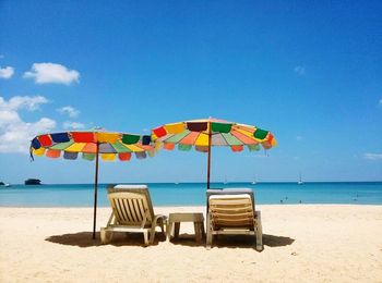 Rear view of sun loungers on calm beach