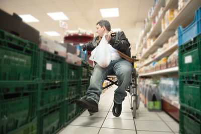 A disabled person in a wheelchair buys groceries