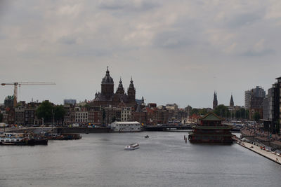 View of buildings at waterfront against cloudy sky