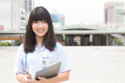 Young female doctor standing in city