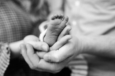 Midsection of parents holding newborn