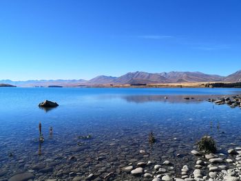 Scenic view of lake with glaciale waters against blue sky