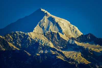 Scenic view of snowcapped mountains against clear blue sky