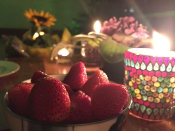 Close-up of fresh strawberries with illuminated tea light