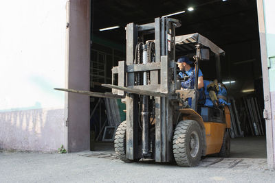 Worker driving forklift and loading glass constructions
