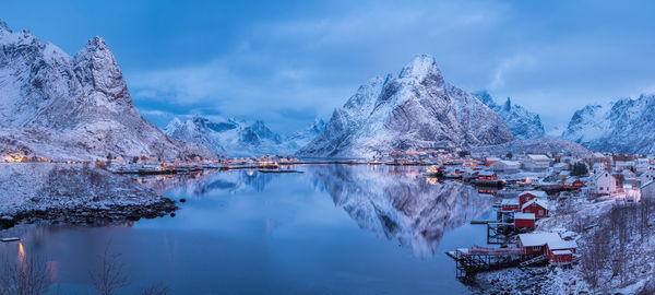 Panoramic view of snowcapped mountains by river against sky