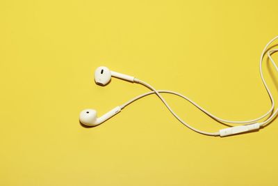 Close-up of telephone pole against yellow background