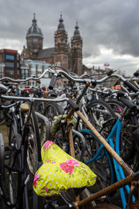 Close-up of bicycle by building in city against sky