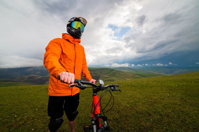 Side view of man riding bicycle on field