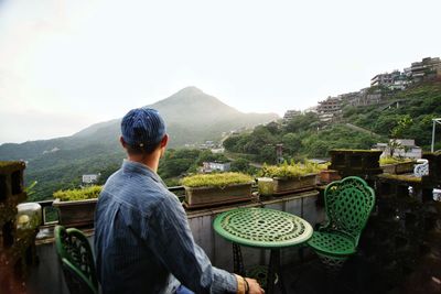 Rear view of man on mountain against sky