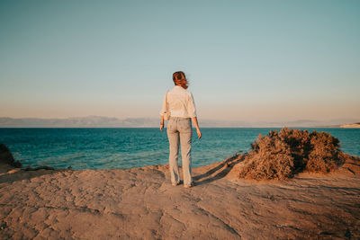 Man standing at beach against sky