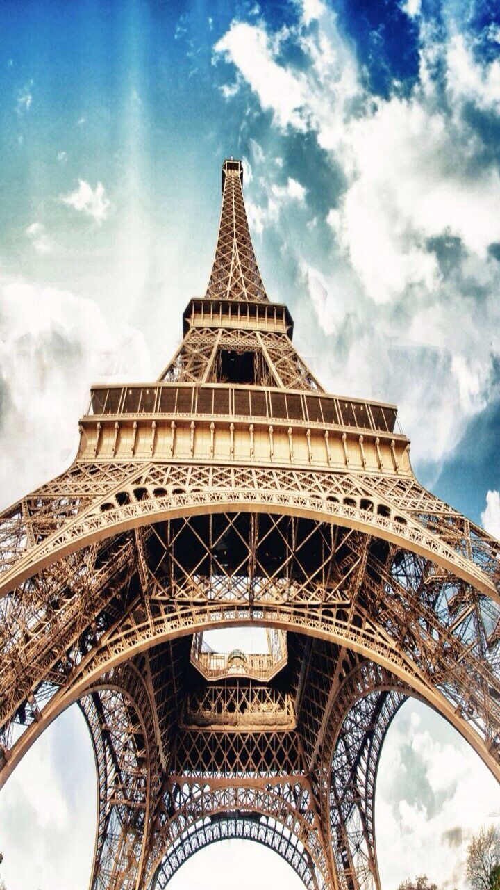 famous place, architecture, international landmark, built structure, travel destinations, tourism, low angle view, eiffel tower, travel, capital cities, culture, sky, tower, history, tall - high, cloud - sky, architectural feature, cloud, metal, city