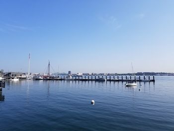 Sailboats in sea against clear blue sky