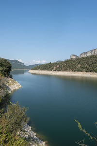 Scenic view of lake against clear blue sky