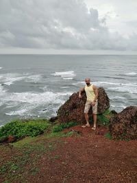 Man standing at beach against sea and sky