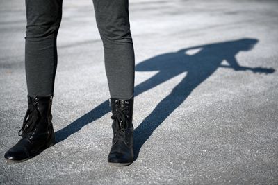 Low section of woman standing on road