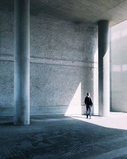 Rear view of man standing against wall