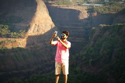 Man taking selfie while standing against mountain