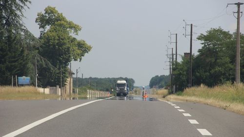 Road amidst trees against clear sky