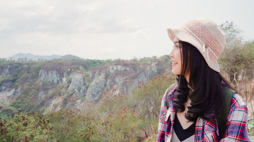 Portrait of beautiful woman standing against sky