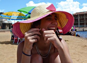 Portrait of young woman with hat on beach