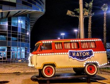 Vintage car against illuminated building at night