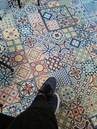 Low section of person standing on tiled floor
