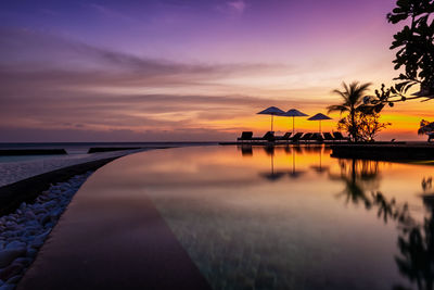 Scenic view of swimming pool against dramatic sky during sunset