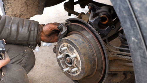 Cropped image of male mechanic repairing car