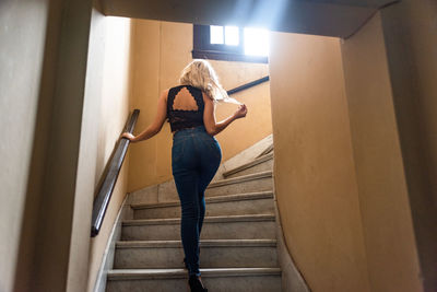 Rear view of woman standing on staircase