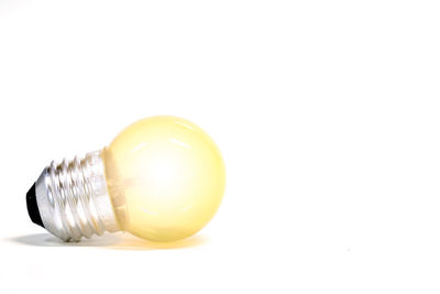 Close-up of light bulb against white background