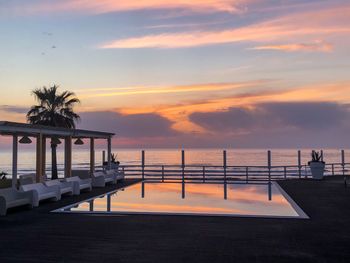 Scenic view of swimming pool against sky during sunset