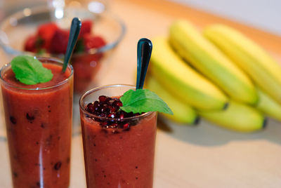Close-up of juices by bananas on table