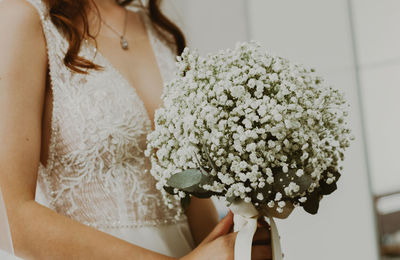 Portrait of a young unrecognizable caucasian bride with a bouquet of boutonnieres.