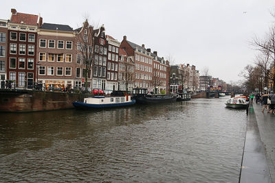 Canal amidst buildings against sky in city