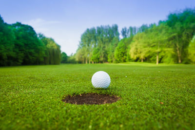 Close-up of ball on golf course against sky