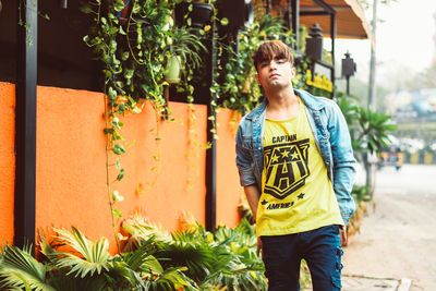 Full length of young man standing against plants