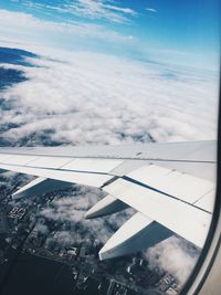 Low angle view of airplane wing over landscape