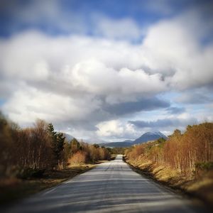 Country road against cloudy sky