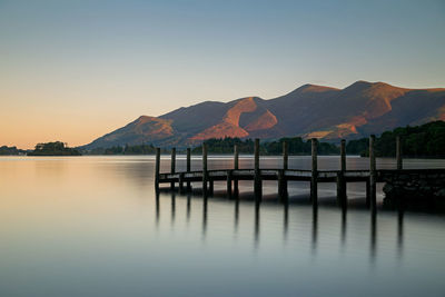 Scenic view of lake against clear sky during sunset