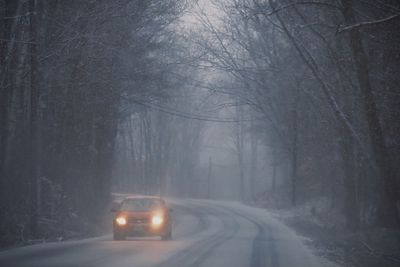 Car driving down a snowy country road