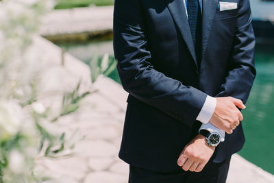 Midsection of man wearing suit during sunny day