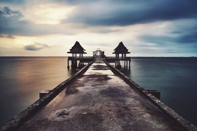 Pier over sea against sky during sunset