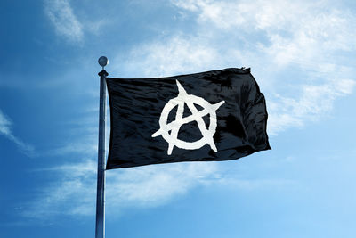 Low angle view of flag against blue sky