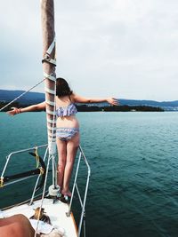 Low angle view of woman sailing on sea against sky